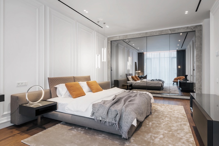 Пространство спальни, двуспальная кровать, комод, тумбочка, шкаф с зеркальным фасадом