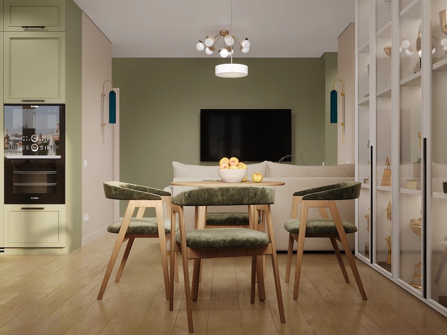 Пространство кухни-гостиной, круглый стол с фруктами, мягкие стулья, застекленный стеллаж, диван, ТВ-панель, встроенная кухня