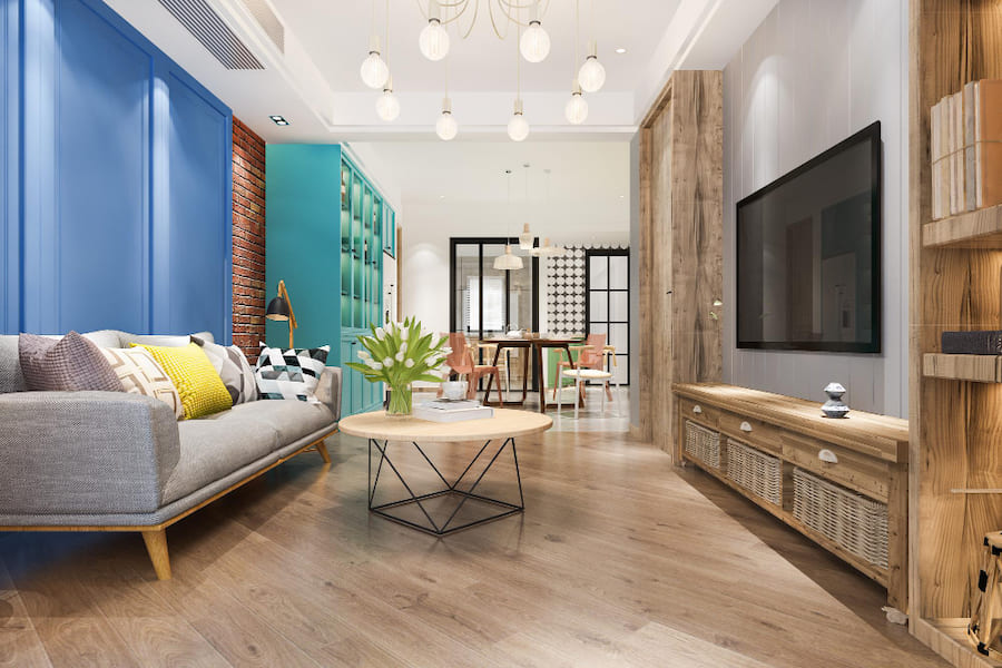 Кухня-гостиная, обеденный стол со стульями, сервант, диван с подушками, журнальный стол, тюльпаны в вазе, книги, чашка, ТВ панель, подвесные люстры, торшер