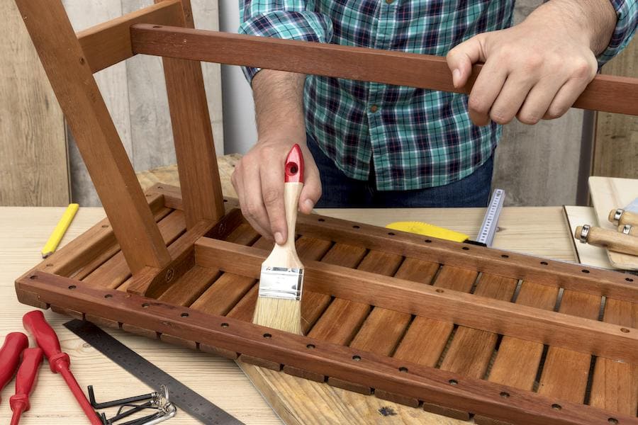 Мастер реставрирует скамейку