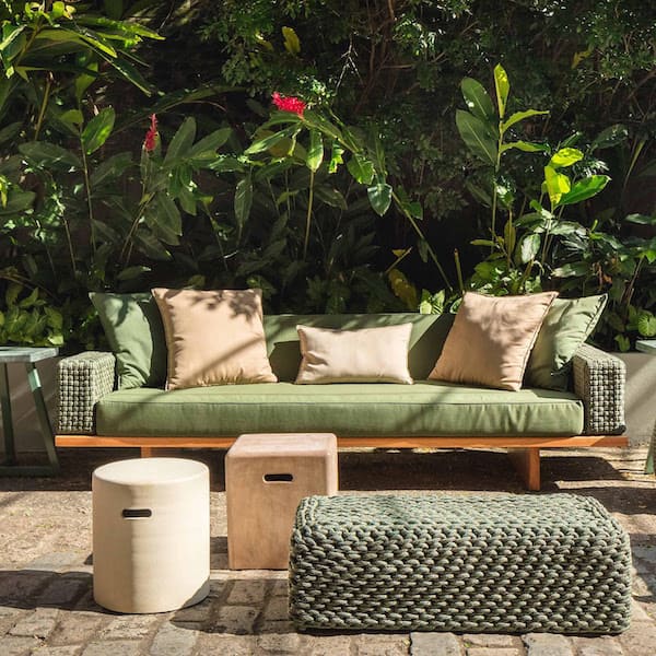 Создать иллюзию единства между мебелью и природой можно, используя краски, которые являются наиболее распространёнными в природной среде Диван с зеленой обивкой и деревянные тумбочки в саду