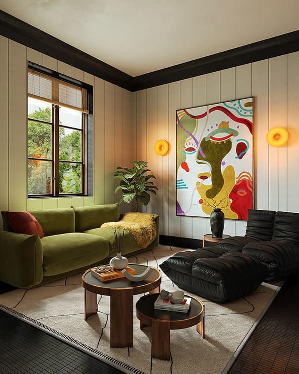 Абстрактная картина является фокусной точкой и выполняет роль визуального якоря в интерьере. Она привлекает внимание, вызывает эмоциональный отклик и оживляет пространство Интерьер комнаты середины 20 века, мягкая мебель разной фактуры и цвета, два журнальных столика, большая яркая картина на стене