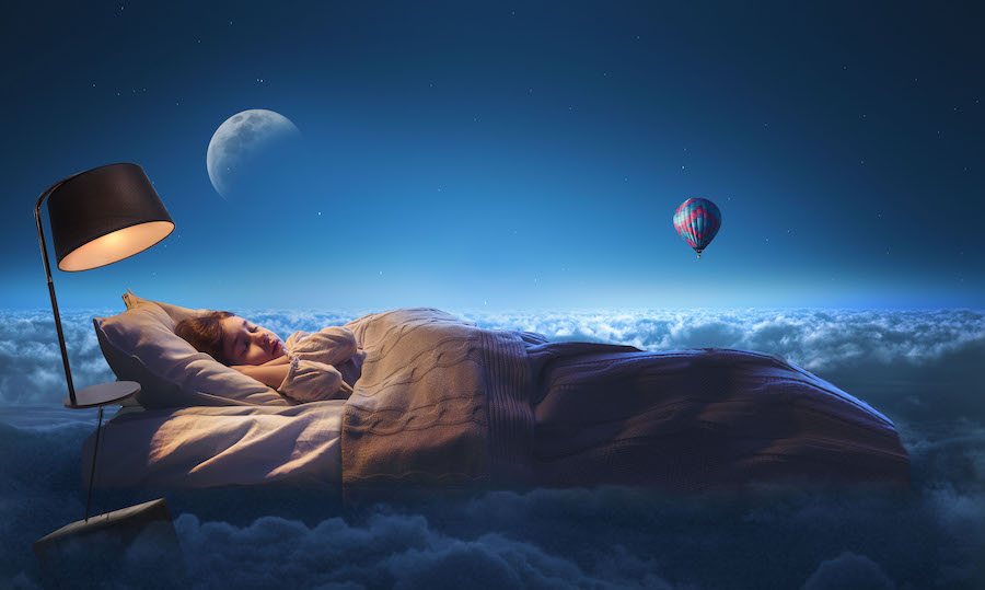 Ребенок спит на матрасе в облаках