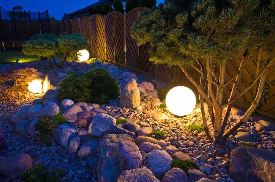 Круглые фонари, подсвечивающие кустарники
