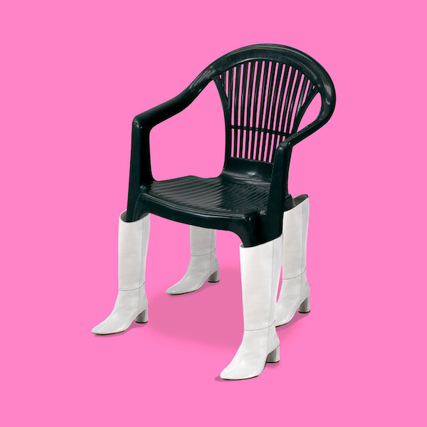 Черный стул в белых сапогах на розовом фоне