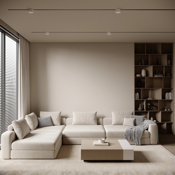 Натуральный текстиль и теплые бежевые тона добавляют тепло и уют в минималистичный интерьер Угловой диван с подушками и пледом, встроенный стеллаж с книгами и вазами, журнальный стол с кружкой, жалюзи на окне