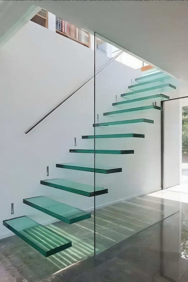 Спальня, двуспальная кровать, в изголовье зеленая стена, две тумбочки, картина на стене, корзина с полотенцем, два подвесных светильника и трековая система освещения