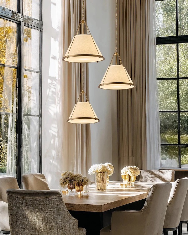 Подвесные светильники над столом являются фоновым освещением и выполняют эстетическую функцию Угол гостиной с панорамными окнами, стол с вазами, обеденные кресла, три разноуровневых подвесных светильника