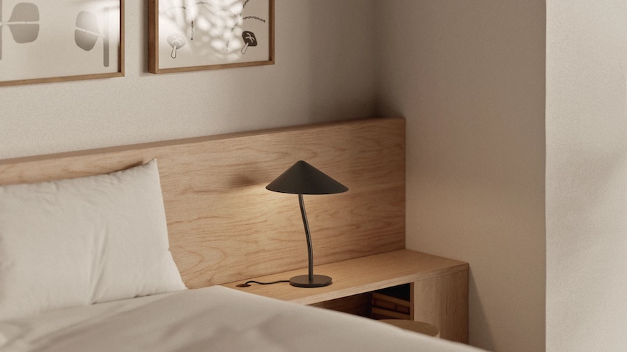Настольная лампа обеспечивает нужную освещённость там, где она нужна, и не тратит световой поток на остальные части комнаты Фрагмент спальни, кровать, тумбочка, постеры на стене, настольная лампа - грибок