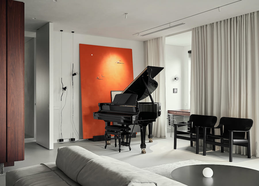 Гостиная, рояль, красное акцентное панно, два деревянных кресла, диван, журнальный стол, трековое освещение