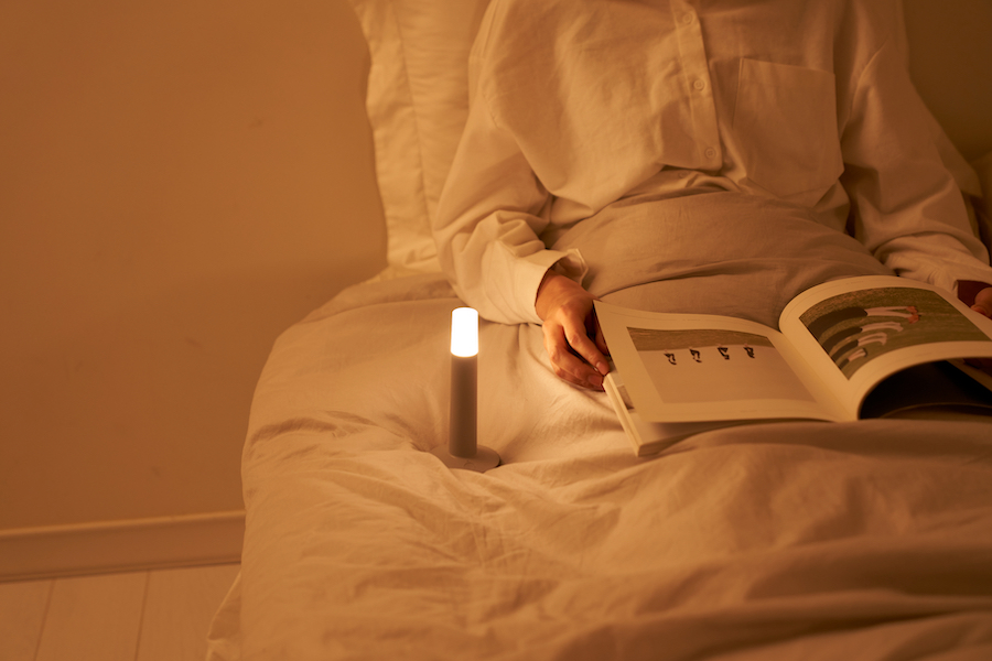 Девушка читает книгу при свете лампы-свечи
