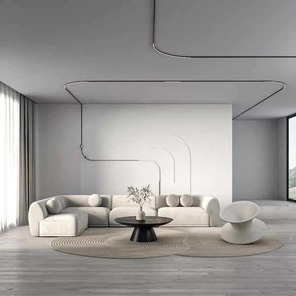 Ременные трековые системы используют гибкую ленту вместо жёсткого шинопровода и применяются, когда нужно создать нестандартные световые линии Пространство гостиной, панорамные окна, угловой диван с круглыми подушками, журнальный стол с вазой, плавные изгибы трековой системы освещения